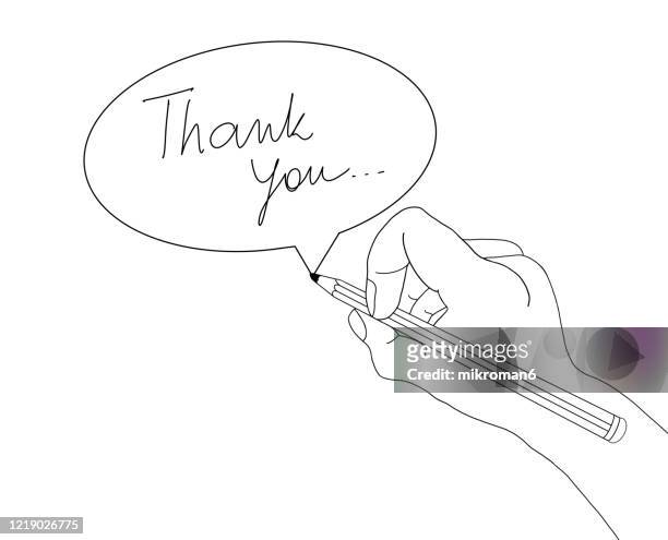 hand holding a pencil drawing a speech bobble with text thank you - thank you englischer satz stock-fotos und bilder