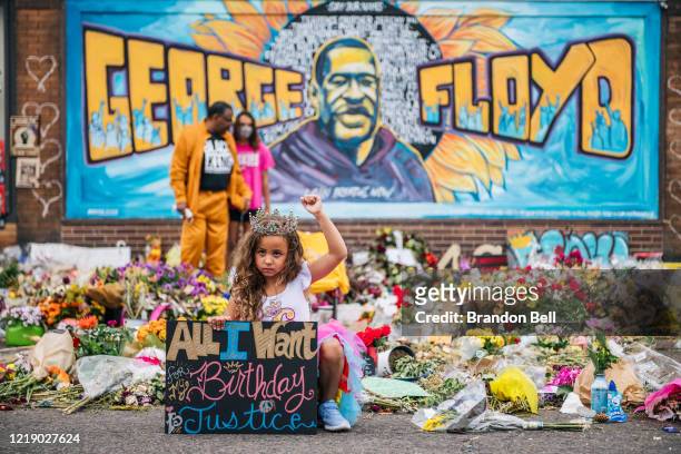 Girl holds her fist in the air while visiting the memorial for George Floyd on June 9, 2020 in Minneapolis, Minnesota. Residents of the community,...