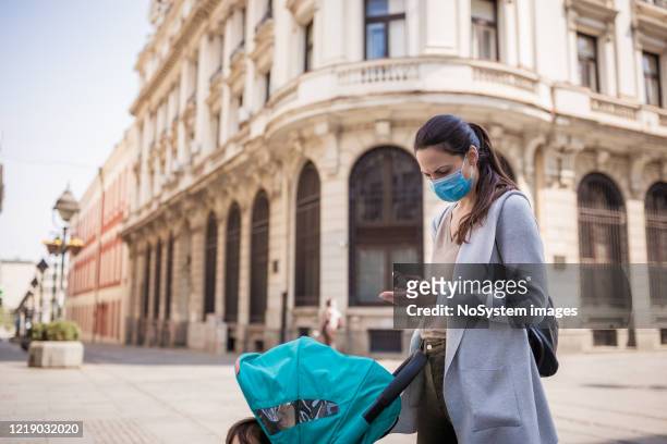 la mère désinfecte ses mains dans la rue - serbie photos et images de collection
