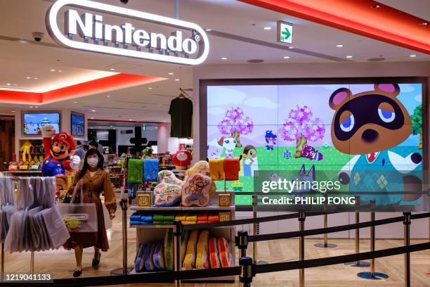 Screen showing the characters from the Animal Crossing series video game is seen at a Nintendo store in Tokyo on June 10, 2020.