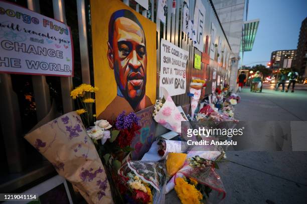 New Yorkers pay tribute to George Floyd by hanging his photo and his name written on papers on a wall and leaving flowers on his funeral day on the...