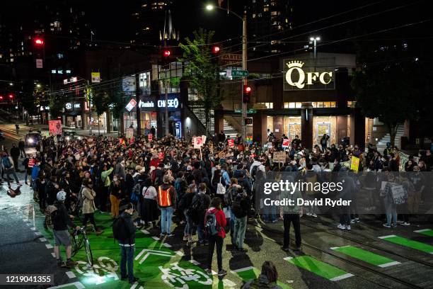 Demonstrators rally in a Capitol Hill neighborhood intersection after marching inside Seattle City Hall, led by Seattle City Council member Kshama...