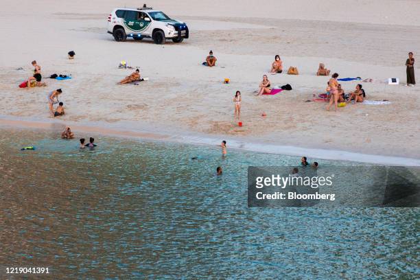 Police patrol the beach occupied by sunbathers and leisure seekers in the Dubai Marina district in Dubai, United Arab Emirates, on Monday, June 8,...