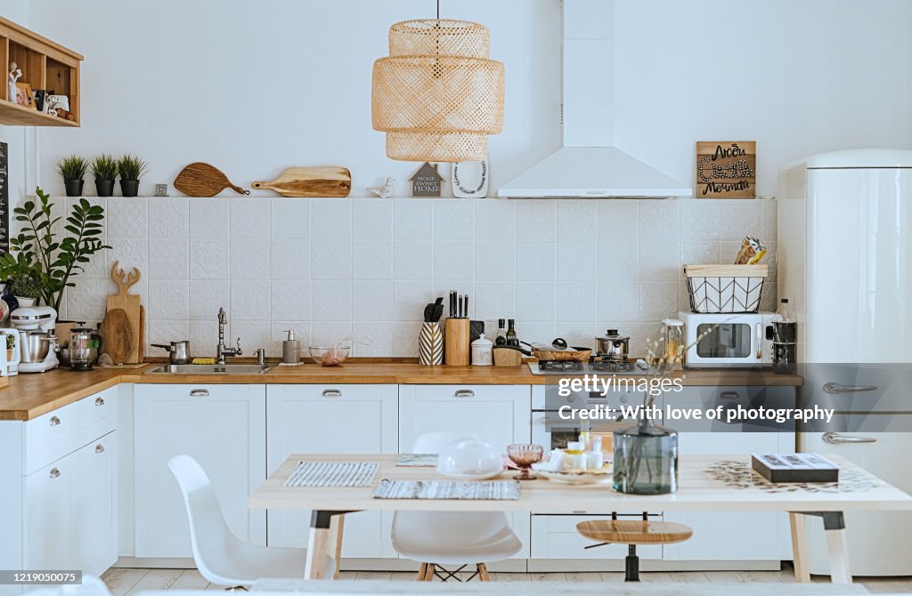 Scandinavian style cozy modern kitchen interior with a dining zone, white modern interior, everyday still llife, stay at home coronavirus quarantine, chores
