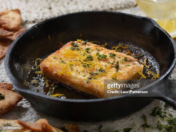 breaded, pan fried feta cheese with lemon zest, cracked black pepper and thyme also known as saganaki - feta cheese imagens e fotografias de stock