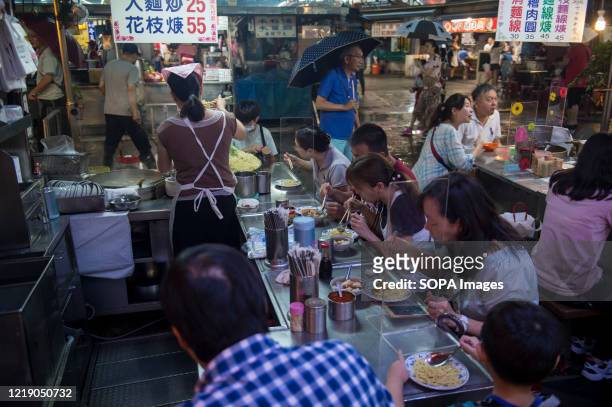 People having street food in a night market with no social distancing restrictions. The Central Epidemic Command Center of the Taiwanese government...