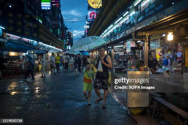 People are seen walking in a local night market after the ease of the lockdown. The Central Epidemic Command Center of the Taiwanese government...