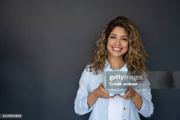 woman holding a piggybank with her savings - coin bank stock pictures, royalty-free photos & images