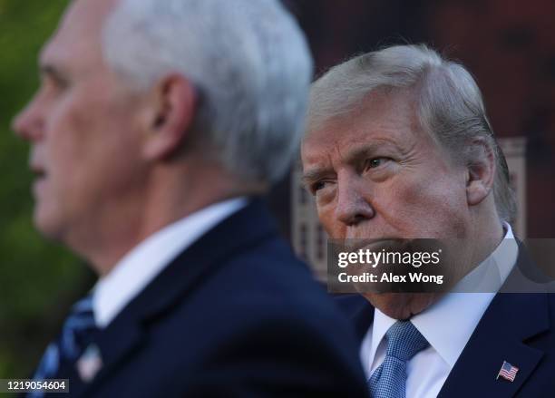 President Donald Trump listens to Vice President Mike Pence speak during the daily briefing of the White House Coronavirus Task Force in the Rose...