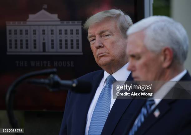 President Donald Trump listens to Vice President Mike Pence speak during the daily briefing of the White House Coronavirus Task Force in the Rose...