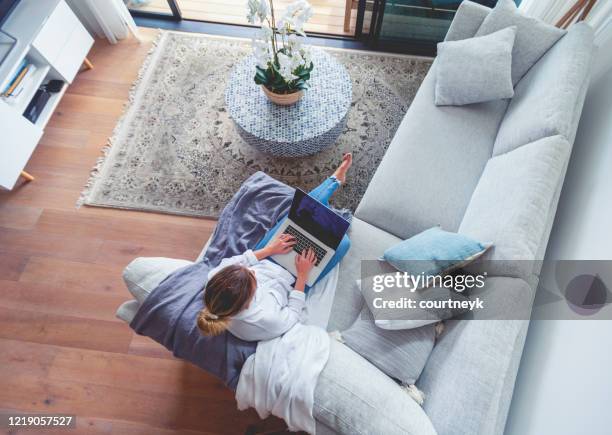 frau mit einem laptop auf dem sofa sitzend. - coffee table from above stock-fotos und bilder