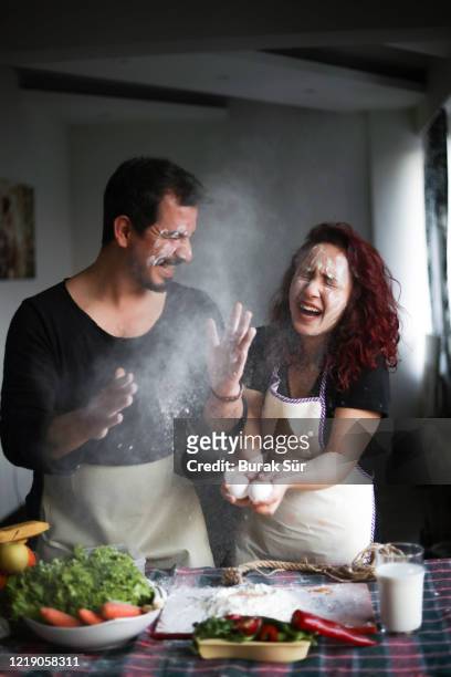 paar plezier in de keuken, thuis blijven, quarantaine activiteit thuis - cooking together stockfoto's en -beelden