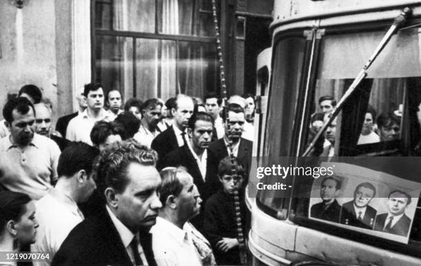 Une foule se recueillent dans les rues de Moscou, le 30 juin 1971, devant les portraits des trois cosmonautes soviétiques, le commandant Georgij...