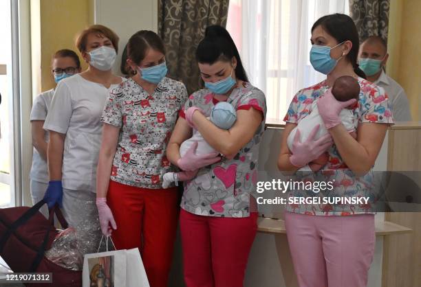 Nurses hold babies as foreign couples gather to collect them in the hotel Venice in the Ukrainian capital of Kiev on June 10, 2020. - Eight foreign...