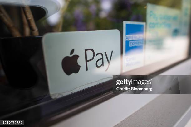 Sticker advertises Apple Pay as an accepted payment method at a restaurant in Norwich, U.K., on Tuesday, June 9, 2020. With the economy on course for...