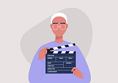 Movie production, young male character holding a clapper board, video industry