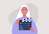 Movie production, young female character holding a clapper board, video industry