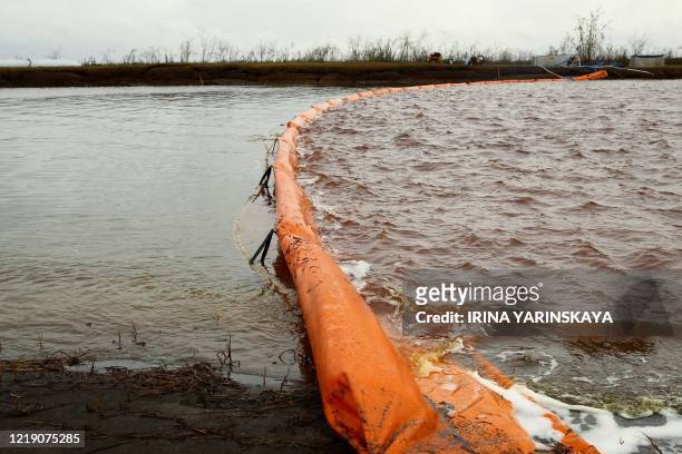 Floating dam is installed to limit the spread of oil pollution following a massive fuel spill in the Ambarnaya River outside Norilsk on June 10,...
