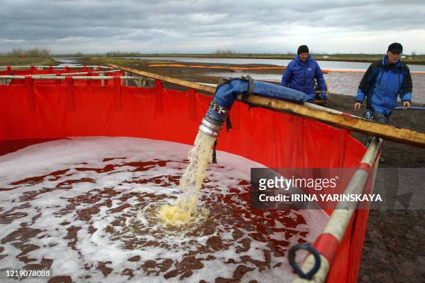 Employees of Russia's state-owned oil pipeline monopoly Transneft take part in a clean-up operation following a massive fuel spill in the Ambarnaya...