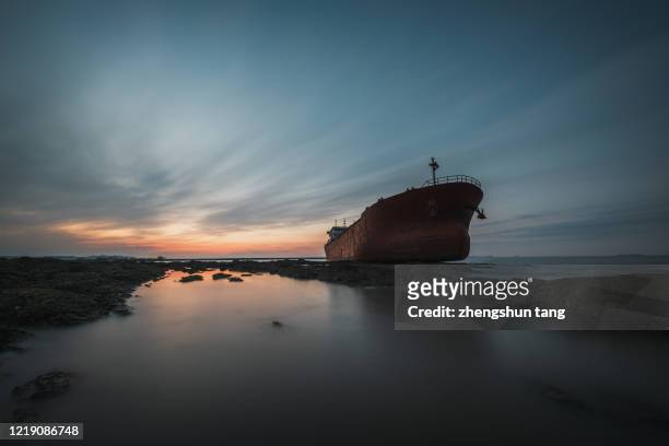stranded iron armored sand ship docked on the coast - ironclad stock-fotos und bilder