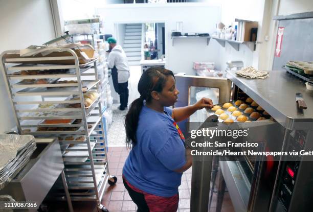 Andrea Scott checks on a tray of cupcakes baking in David Benton"u2019s Sugarsweet Cake and Cookie Studio in Oakland, Calif. On Wednesday, April 15,...