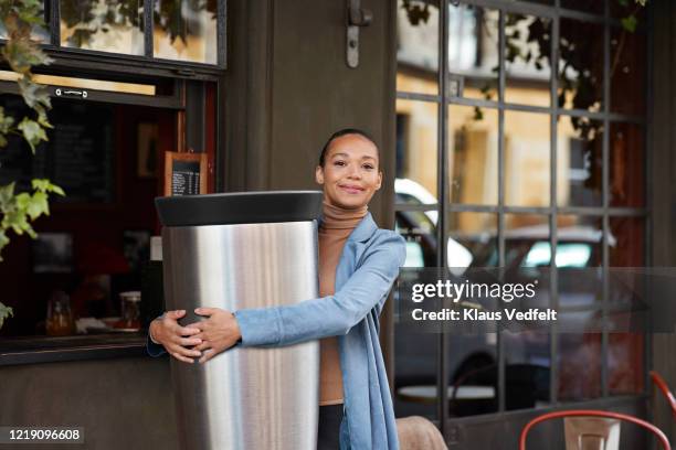 young woman holding large reusable coffee cup outside cafe - cup sizes stock pictures, royalty-free photos & images