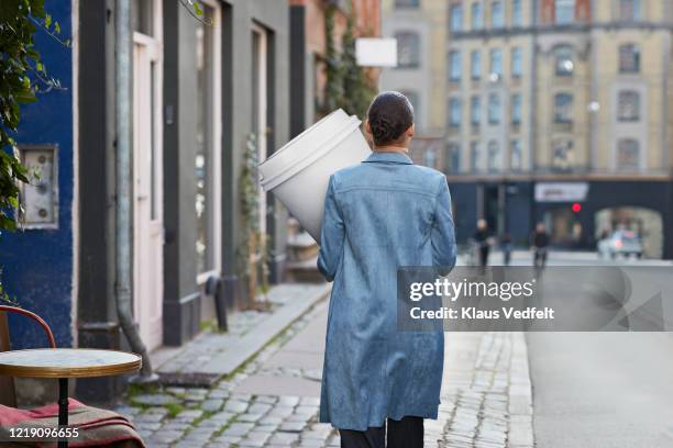 woman carrying large disposable coffee cup while walking on footpath - cup sizes stock pictures, royalty-free photos & images