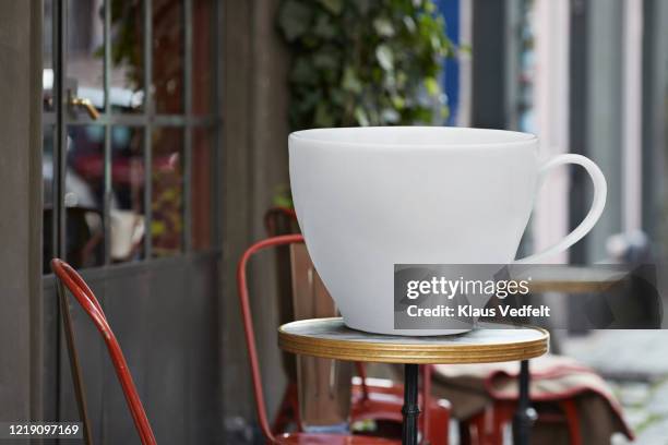 large white coffee cup on table at sidewalk cafe - cup sizes stock pictures, royalty-free photos & images