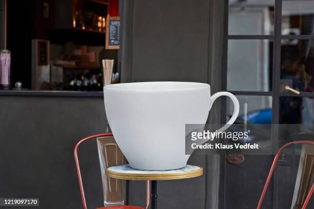 large coffee cup on table at sidewalk cafe - cup sizes stock pictures, royalty-free photos & images