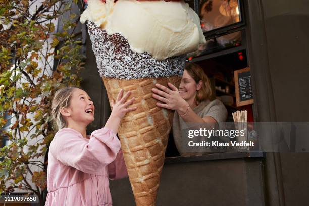 girl buying large ice cream cone from take out counter of cafe - copenhagen food stock pictures, royalty-free photos & images