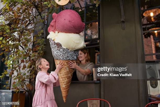 girl buying large ice cream cone from take out counter of cafe - big ideas stock pictures, royalty-free photos & images