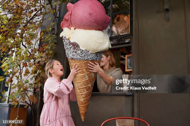 girl buying large ice cream from take out counter of cafe - abundance fotografías e imágenes de stock