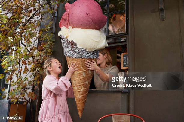 girl buying large ice cream from take out counter of cafe - abundance stock pictures, royalty-free photos & images