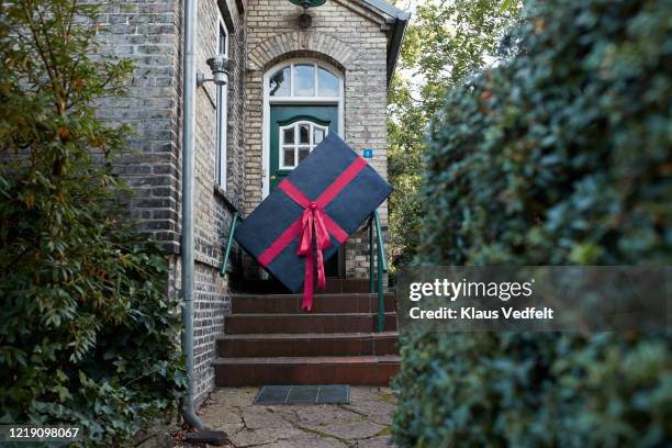 large gift box on steps of house - shopping online blue stock pictures, royalty-free photos & images