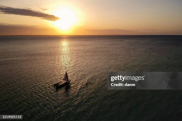 traditional boat in a water during sunset, view from above made with drone, zanzibar, tanzania. - dhow stock pictures, royalty-free photos & images
