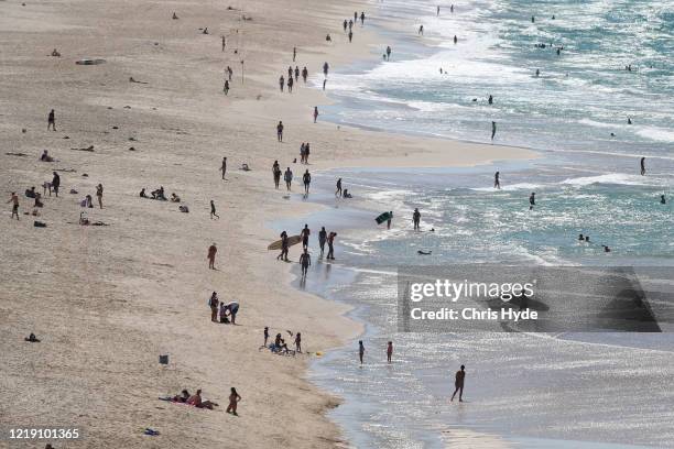Beach goers on Mermaid beach on April 16, 2020 in Gold Coast, Australia. The Federal Government has closed all non-essential business and implemented...