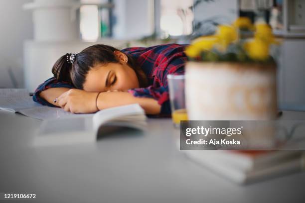 tonårsflicka sover över sitt skrivbord. - gymnasieexamen bildbanksfoton och bilder