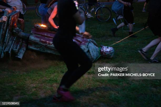 Protesters drag a statue of Christopher Columbus to a nearby pond after pulling it down in Richmond, Virginia, June 9, 2020. - The protest was part...