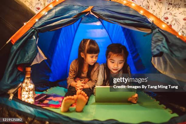 little sisters using digital tablet in a tent at home - development camp stock pictures, royalty-free photos & images