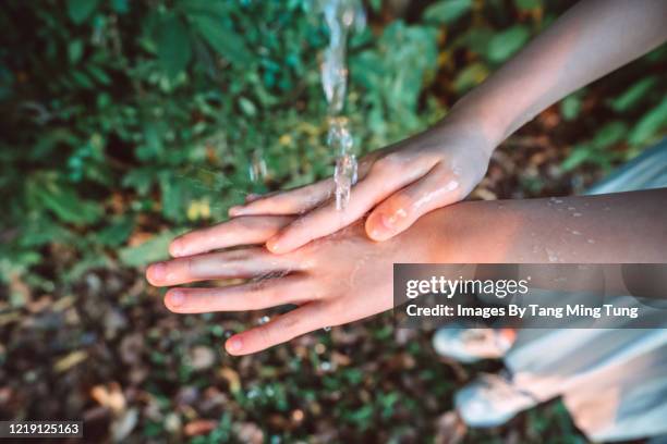 direct above view of a little girl washing her hands with water in park - running water isolated stock pictures, royalty-free photos & images