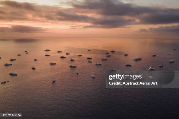 a group of super yachts moored in the bay at sunset seen from an aerial view, monaco - monaco yachts stock pictures, royalty-free photos & images