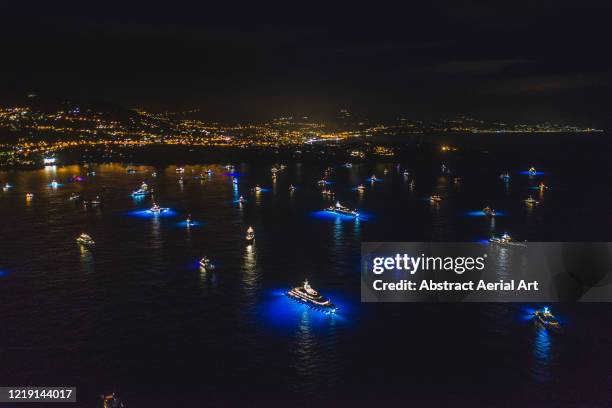 aerial view at night showing numerous super yachts moored in a bay, monaco - monaco nice stock-fotos und bilder