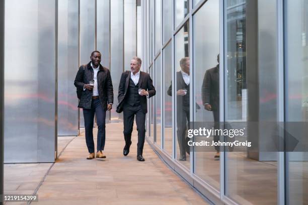 zakenpartners die en op koffieonderbreking lopen spreken - naderen stockfoto's en -beelden