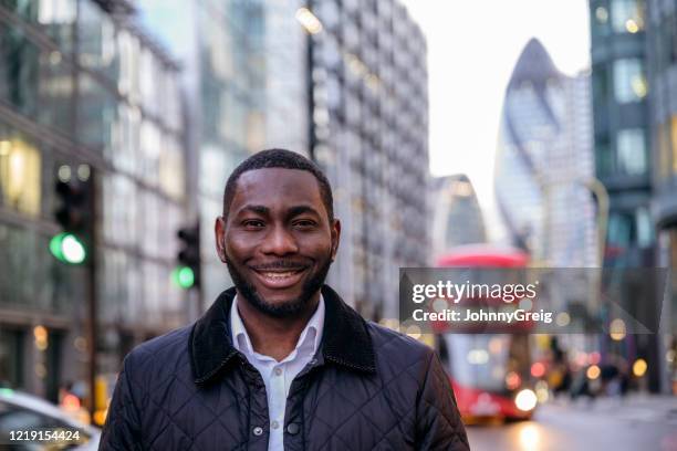 openluchtportret van glimlachende afrikaanse zakenman in londen - london buses stockfoto's en -beelden