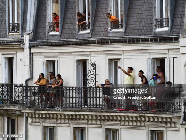 People applaud on their balcony at the neighborhood of "Gobelins" during the confinement of the French due to an outbreak of the coronavirus on April...