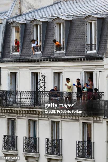 People applaud on their balcony at the neighborhood of "Gobelins" during the confinement of the French due to an outbreak of the coronavirus on April...