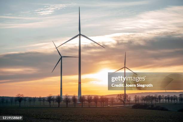 windräder in der abenddämmerung - windrad natur wiese stock-fotos und bilder