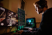 Teenage Boy Playing Multiplayer Games on Desktop Pc in his Dark Room - stock photo