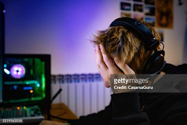 jonge jongen facepalming na het verliezen in video spel - voorraadfoto - defeat stockfoto's en -beelden