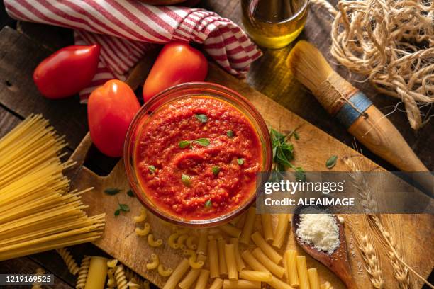 tomatensauce und rohe nudelnzusammensetzung - tomatensoße stock-fotos und bilder